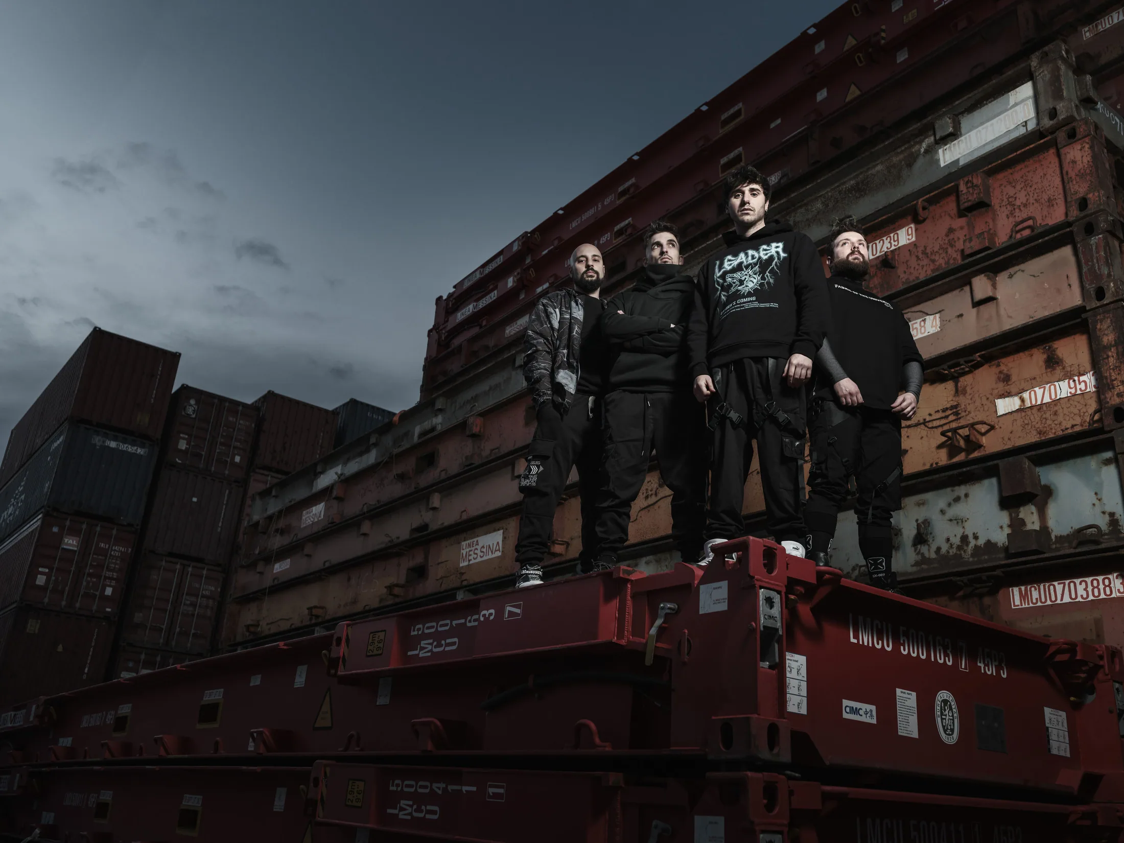 The four members of My Evil Twin standing on stacked containers under a stormy sky